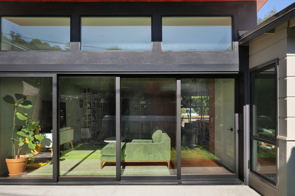 Idee per un soggiorno minimalista di medie dimensioni e aperto con pareti grigie, pavimento in cemento, TV autoportante, pavimento marrone e soffitto a volta