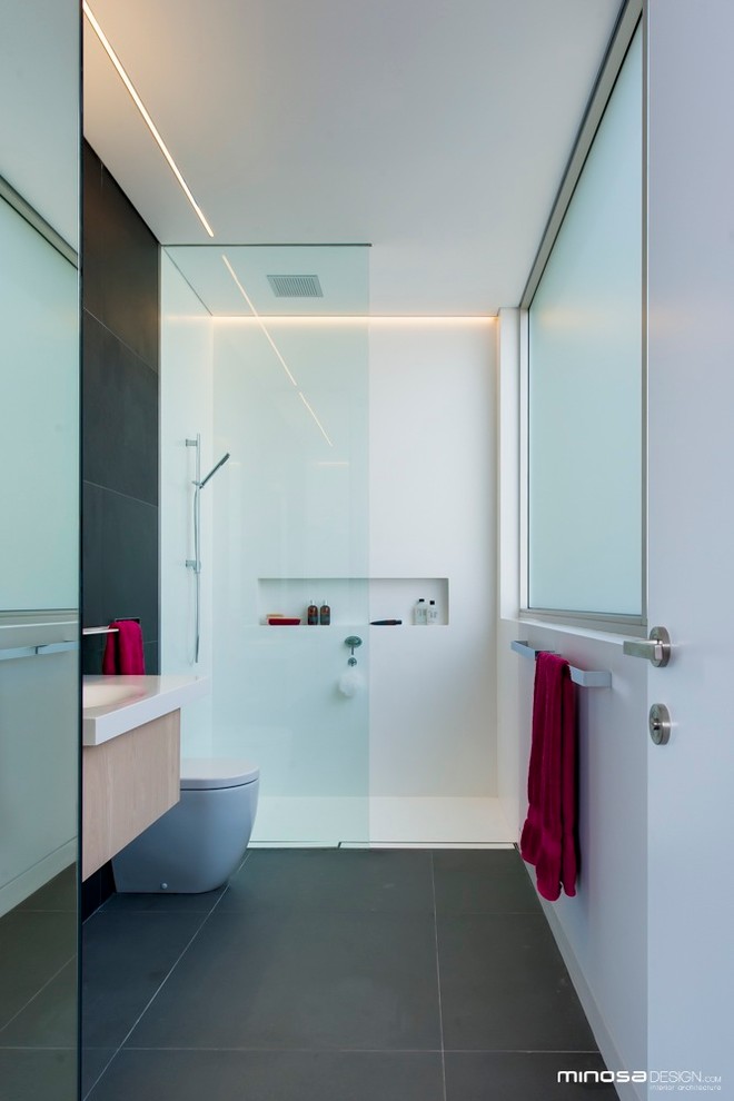 Photo of a modern bathroom in Sydney with an integrated sink, an open shower, solid surface benchtops and gray tile.