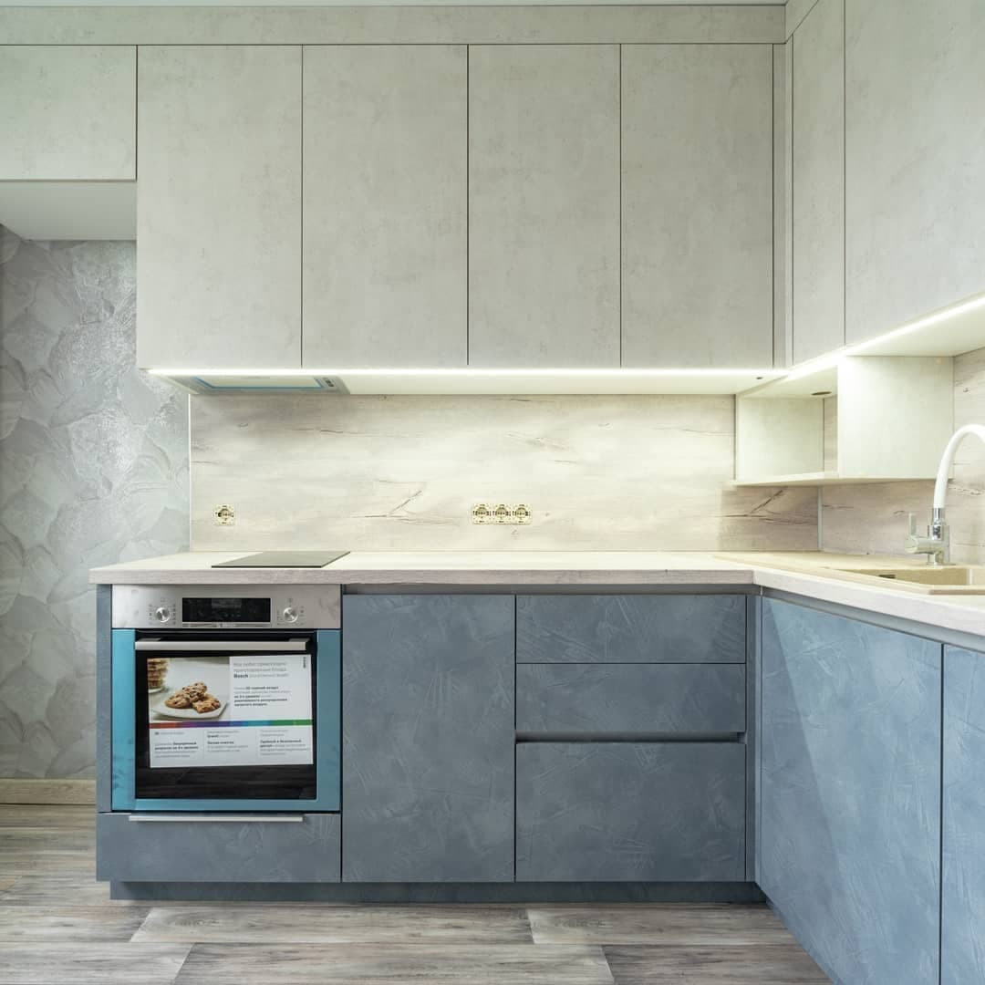 Большая угловая кухня в синем и белом цвете с фасадами под камень