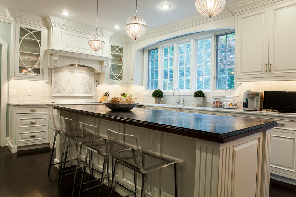 Inspiration for an expansive traditional l-shaped eat-in kitchen in Philadelphia with an undermount sink, raised-panel cabinets, white cabinets, marble benchtops, stainless steel appliances, dark hardwood floors, multiple islands, white splashback and stone tile splashback.