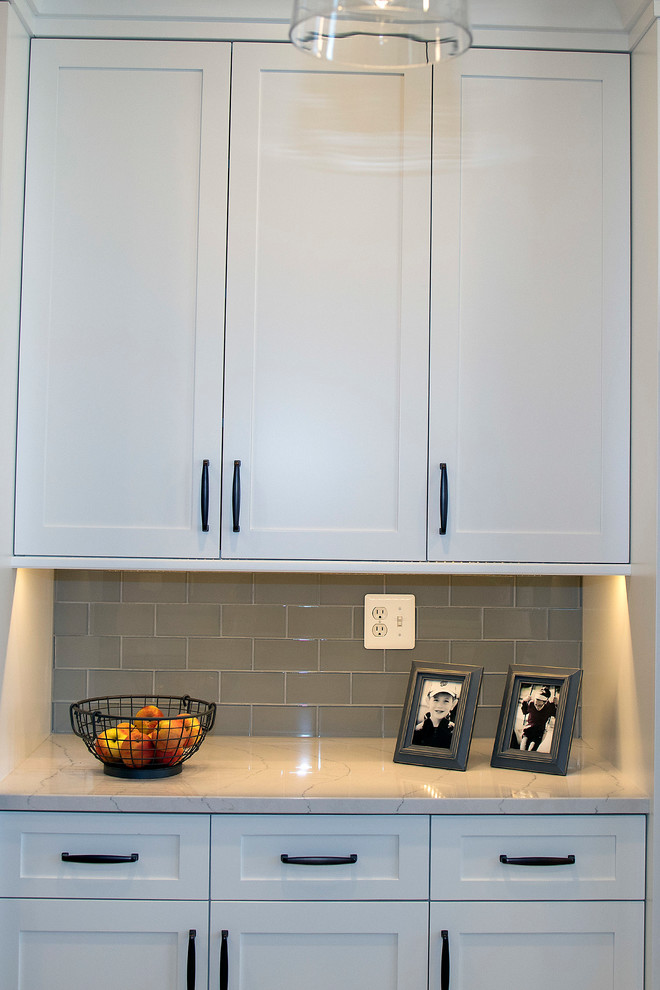 Example of a large transitional u-shaped kitchen design in DC Metro with shaker cabinets, white cabinets and an island