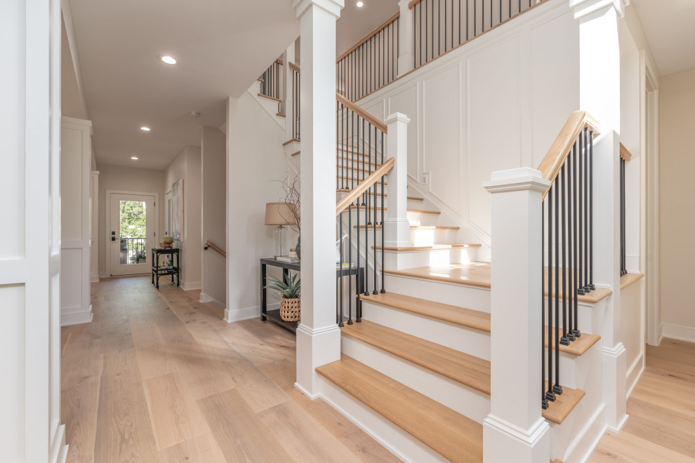 Traditional wood metal railing staircase in Minneapolis with painted wood risers and panelled walls.