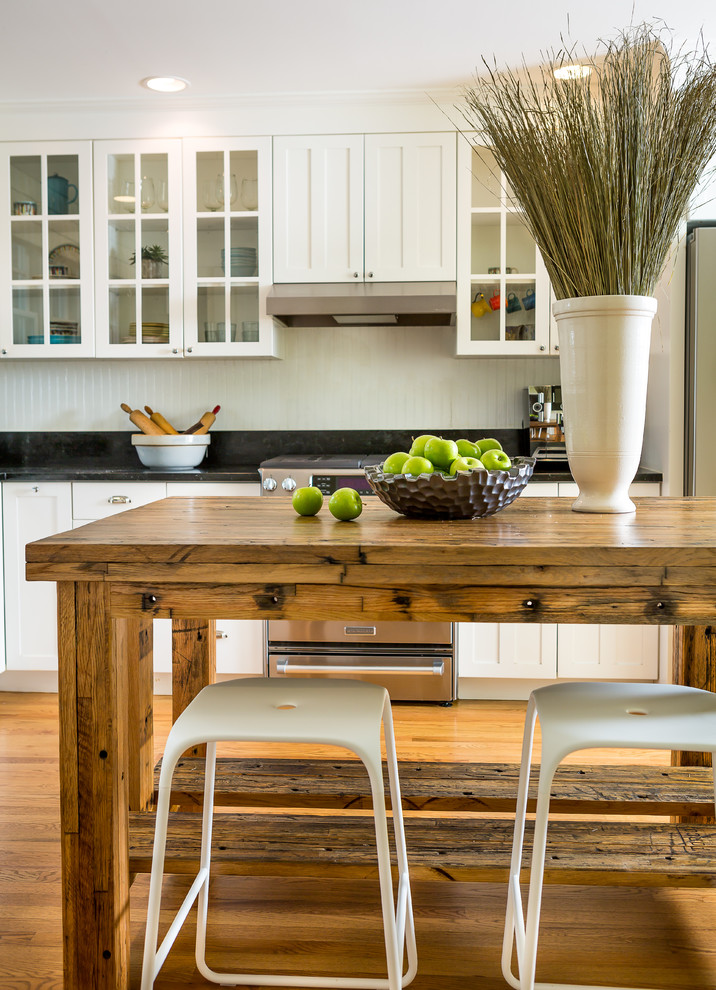 Inspiration for a mid-sized farmhouse l-shaped medium tone wood floor and beige floor enclosed kitchen remodel in Denver with shaker cabinets, white cabinets, an island, wood countertops, white backsplash and stainless steel appliances