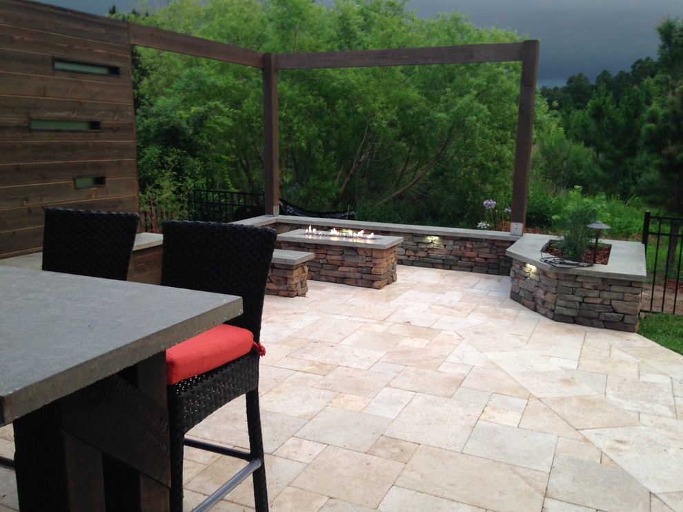 Photo of a mid-sized contemporary backyard patio in Jacksonville with natural stone pavers and a pergola.