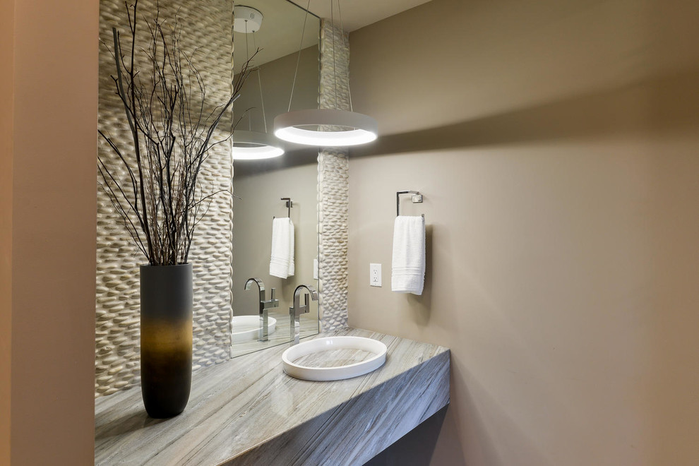Photo of a mid-sized contemporary powder room in Denver with beige walls, an integrated sink, granite benchtops, gray tile and pebble tile.