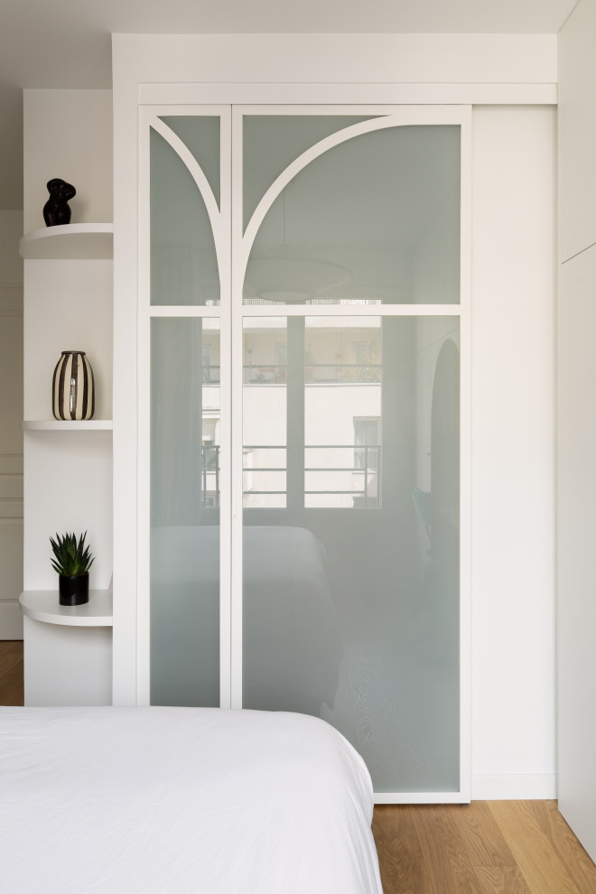 Exemple d'une petite chambre parentale blanche et bois tendance avec un mur blanc, parquet clair, un sol beige et verrière.