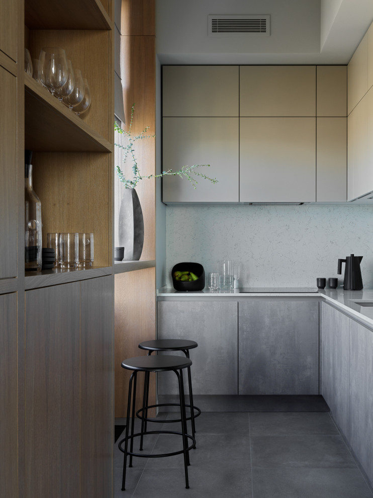 Idéer för ett avskilt, mellanstort modernt vit l-kök, med en undermonterad diskho, släta luckor, beige skåp, bänkskiva i koppar, grått stänkskydd, svarta vitvaror, klinkergolv i porslin och grått golv