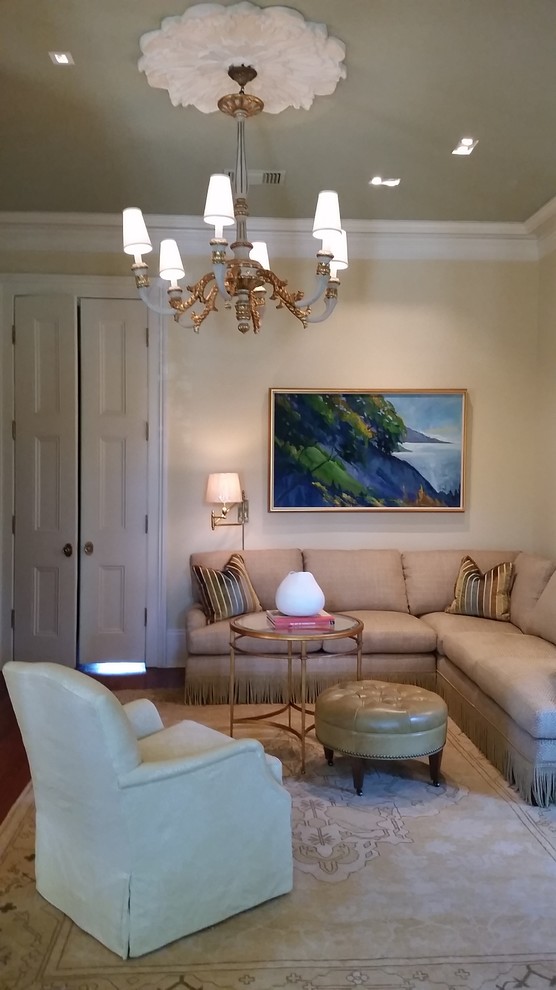 Inspiration for a mid-sized traditional enclosed family room in New Orleans with white walls, medium hardwood floors, a standard fireplace, a stone fireplace surround, a wall-mounted tv and brown floor.