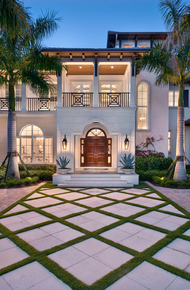 Photo of an expansive tropical two-storey beige exterior in Miami with mixed siding.