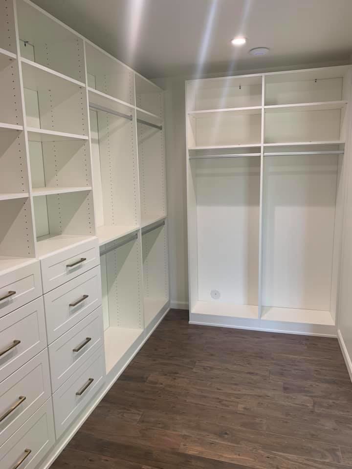 Photo of a large country gender-neutral walk-in wardrobe in Phoenix with shaker cabinets, white cabinets, dark hardwood floors and brown floor.