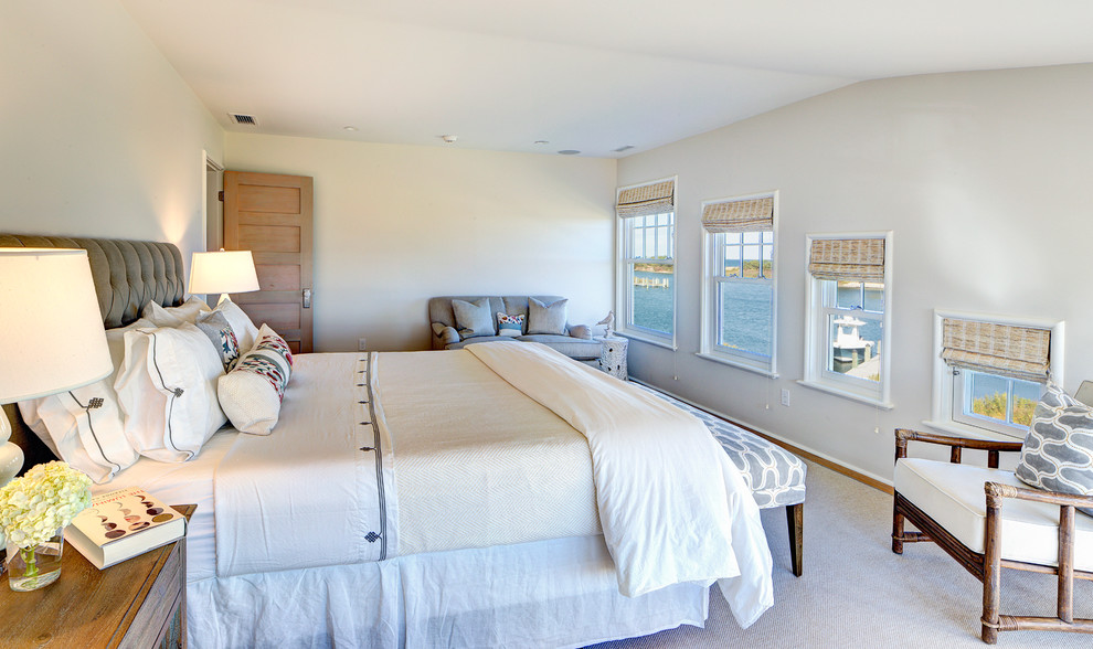 Photo of a beach style bedroom in Boston with grey walls and medium hardwood floors.