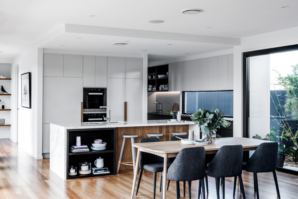 This is an example of a contemporary open plan dining in Brisbane with white walls, medium hardwood floors, no fireplace and beige floor.