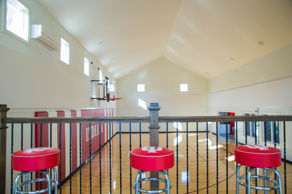 Expansive traditional indoor sport court in Indianapolis with white walls, painted wood floors, multi-coloured floor and vaulted.