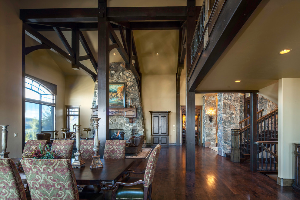 This is an example of an expansive country open plan dining in Salt Lake City with medium hardwood floors, a standard fireplace, a stone fireplace surround and beige walls.