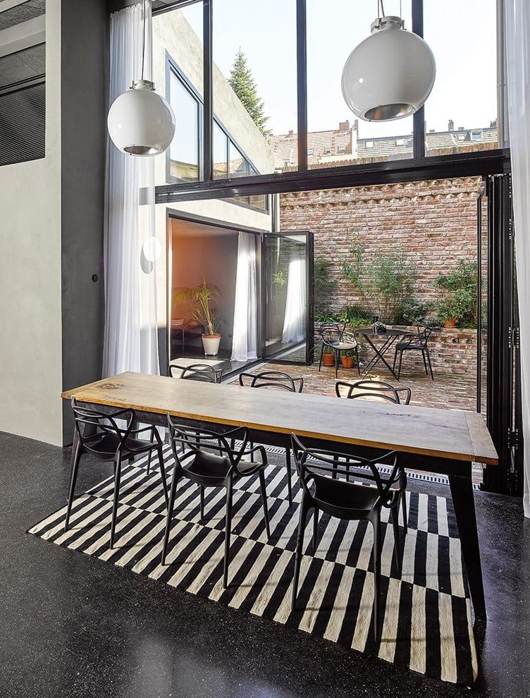 Inspiration for a mid-sized industrial open plan dining in Cologne with white walls, linoleum floors, no fireplace and black floor.