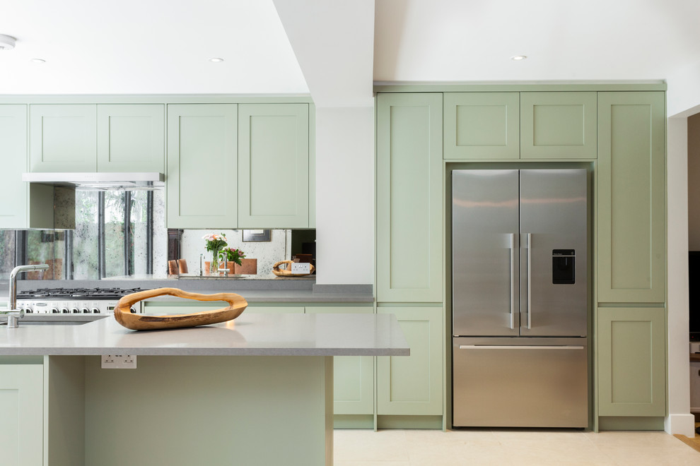 Inspiration for a transitional kitchen in London with an undermount sink, shaker cabinets, green cabinets, metallic splashback, stainless steel appliances and with island.