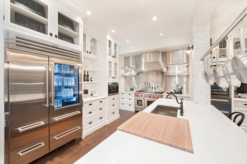 Design ideas for a transitional kitchen in Calgary with an undermount sink, shaker cabinets, white cabinets, metallic splashback, stainless steel appliances, dark hardwood floors and with island.