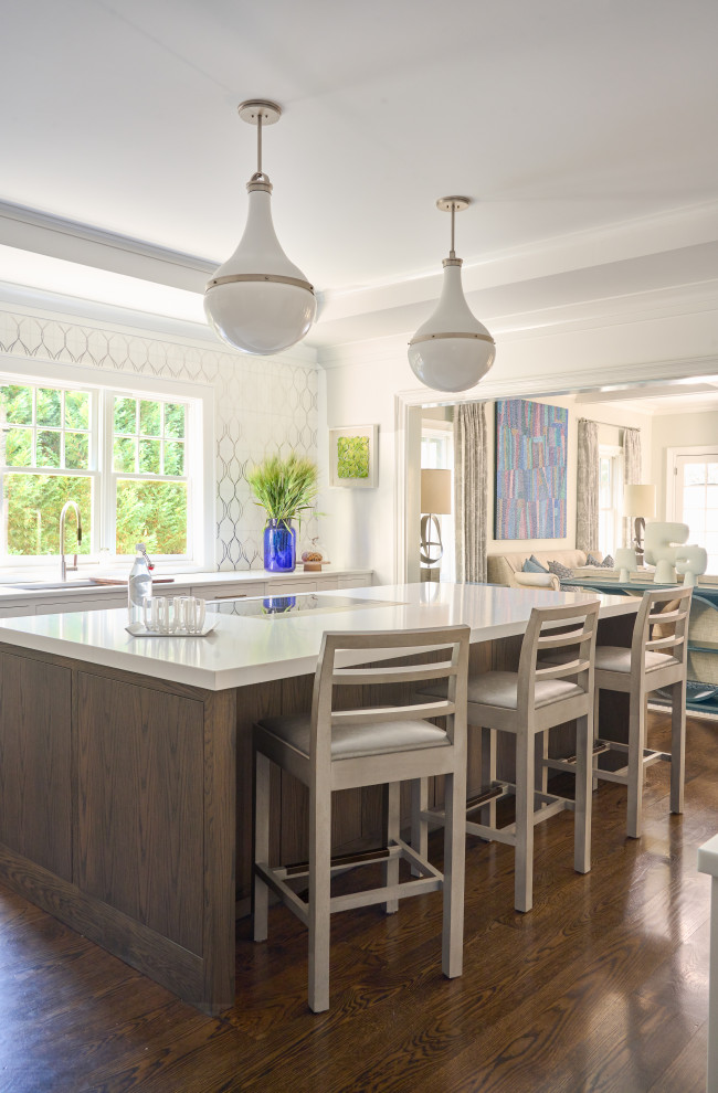 Large transitional u-shaped dark wood floor and brown floor enclosed kitchen photo in New York with an island, an undermount sink, flat-panel cabinets, dark wood cabinets, quartz countertops, white backsplash, mosaic tile backsplash, stainless steel appliances and white countertops
