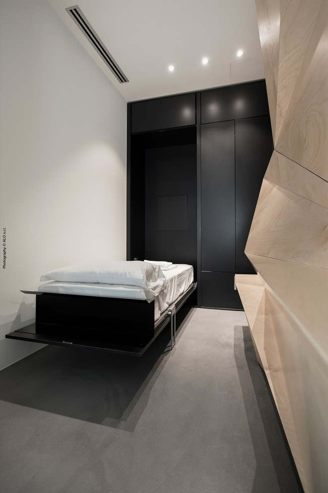 Design ideas for a small contemporary gender-neutral built-in wardrobe in Cagliari with beaded inset cabinets, black cabinets, concrete floors and grey floor.