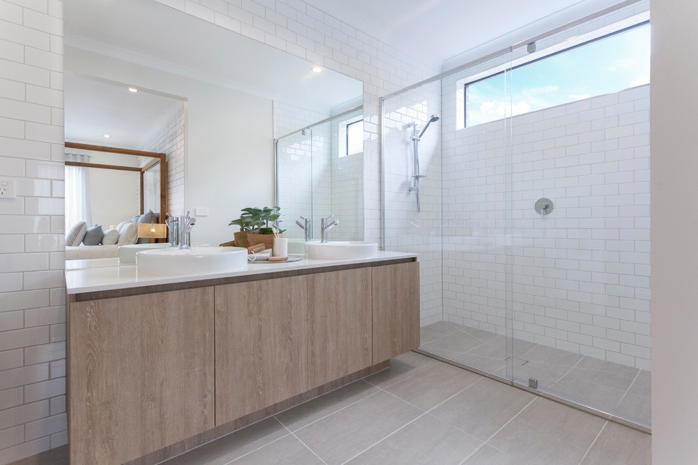 Design ideas for a beach style bathroom in Geelong with louvered cabinets, light wood cabinets, a curbless shower, white tile, white walls, a vessel sink, grey floor, a sliding shower screen and white benchtops.