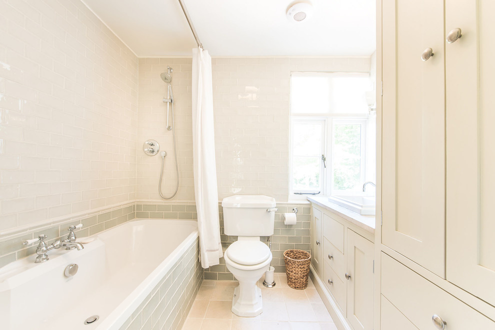 Design ideas for a small traditional bathroom in Berkshire with shaker cabinets, grey cabinets, a drop-in tub, a curbless shower, gray tile, ceramic tile, grey walls, limestone floors, a drop-in sink, limestone benchtops and a two-piece toilet.
