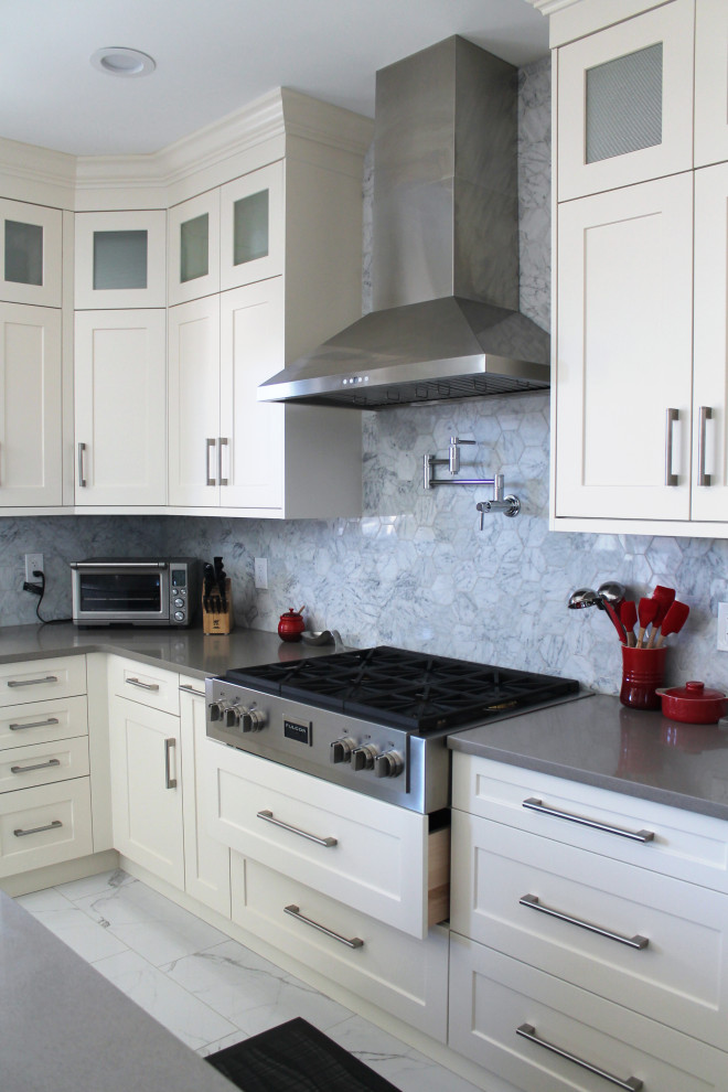 Large transitional u-shaped eat-in kitchen photo with shaker cabinets, white cabinets, quartz countertops, gray backsplash, stainless steel appliances, an island and gray countertops