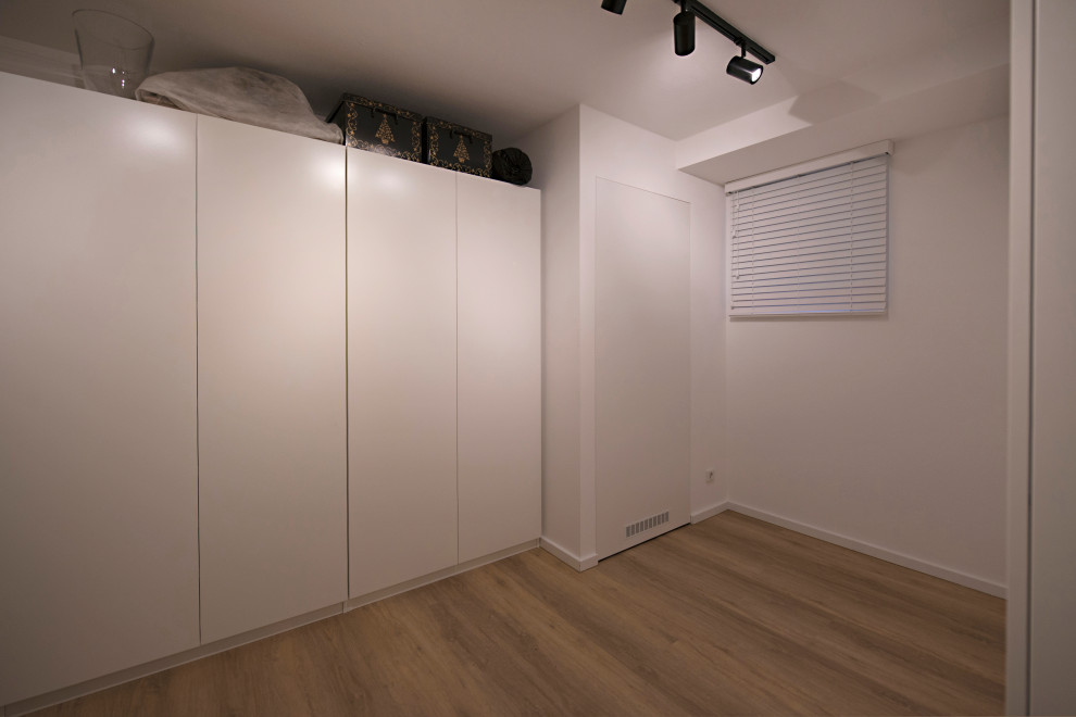 Mittelgroßes Modernes Untergeschoss mit beiger Wandfarbe, Vinylboden und braunem Boden in München