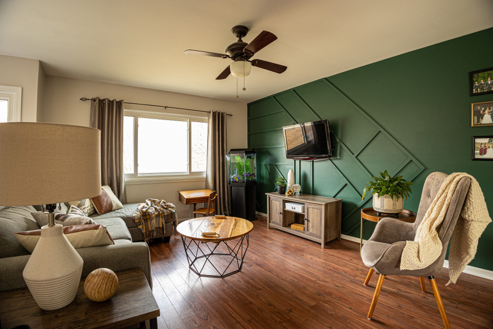 Стильный дизайн: открытая гостиная комната среднего размера в современном стиле с зелеными стенами, полом из винила, телевизором на стене, коричневым полом и панелями на части стены без камина - последний тренд