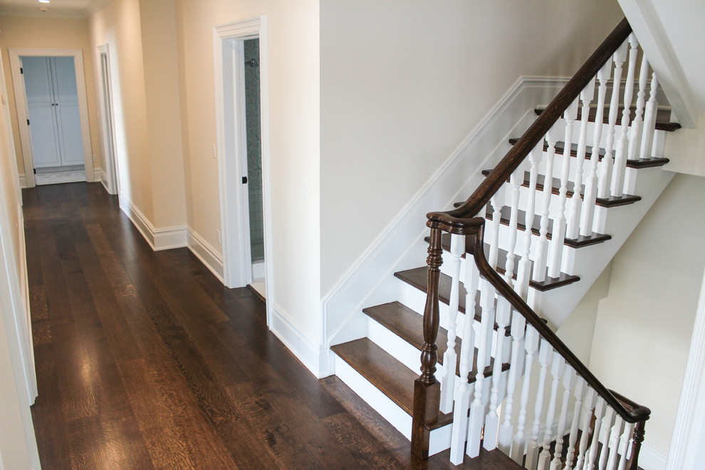 Photo of a large traditional wood u-shaped staircase in New York with painted wood risers.