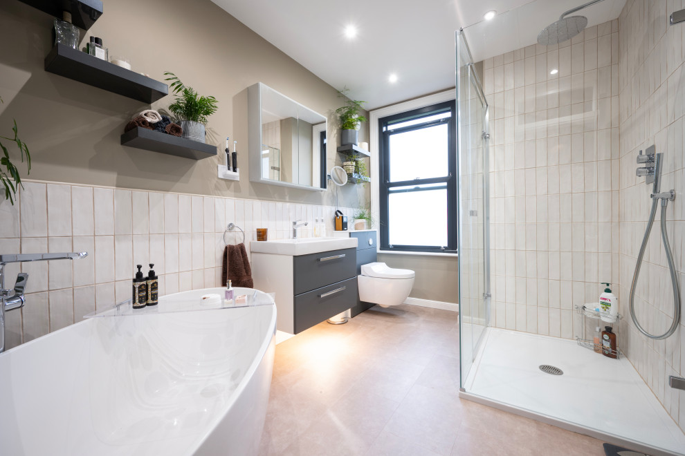 Design ideas for a mid-sized contemporary kids bathroom in Kent with flat-panel cabinets, grey cabinets, a freestanding tub, a corner shower, a bidet, white tile, ceramic tile, green walls, a wall-mount sink, pink floor, a hinged shower door, a single vanity and a floating vanity.