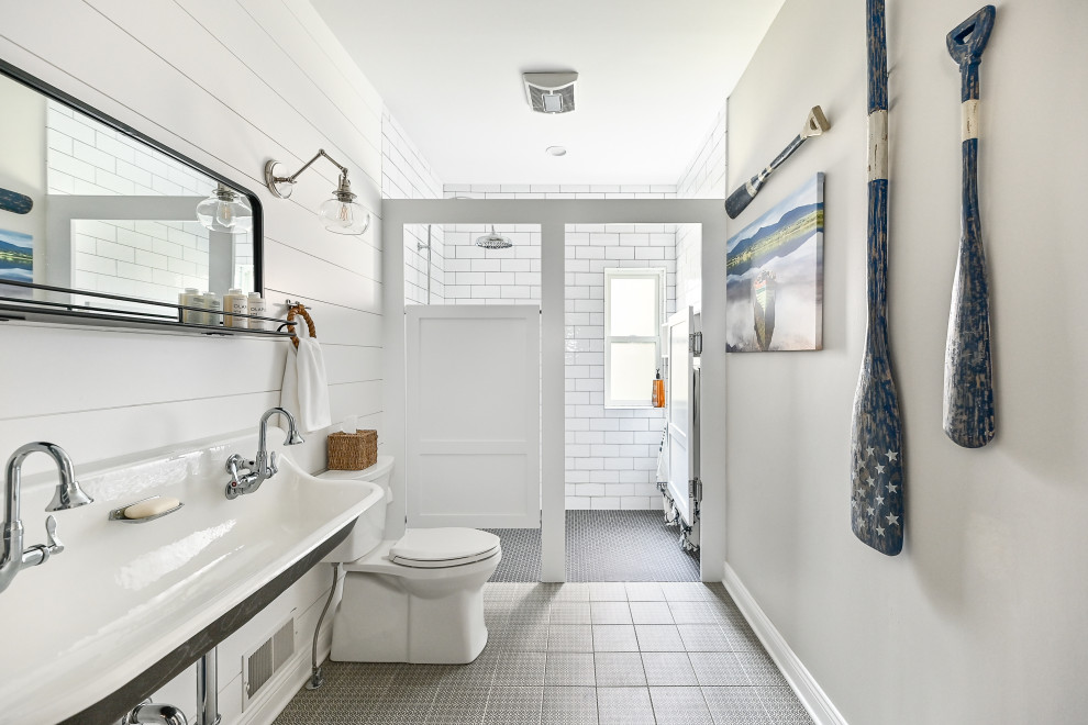 Design ideas for a mid-sized beach style 3/4 bathroom in Milwaukee with a curbless shower, a two-piece toilet, white walls, porcelain floors, a wall-mount sink, black floor, a hinged shower door, a niche, a double vanity, a floating vanity and planked wall panelling.