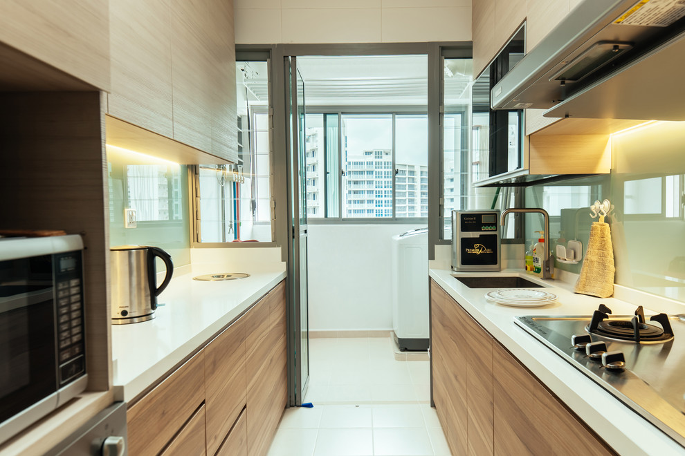 Photo of a small contemporary galley kitchen in Singapore with an undermount sink and flat-panel cabinets.