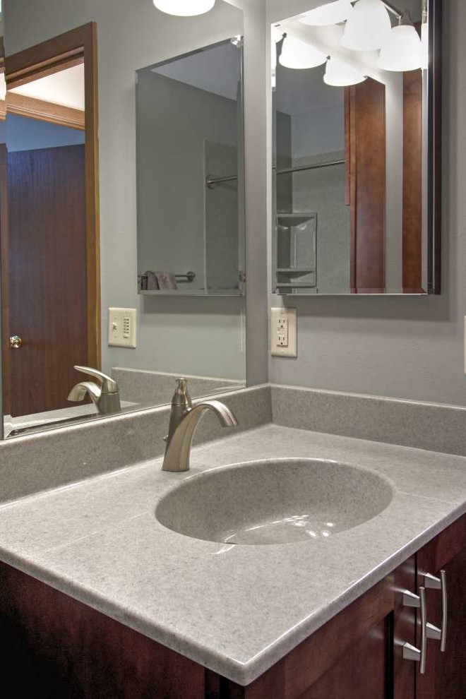 Photo of a mid-sized transitional 3/4 bathroom in St Louis with shaker cabinets, dark wood cabinets, an alcove tub, a shower/bathtub combo, gray tile, grey walls, slate floors, an integrated sink and onyx benchtops.