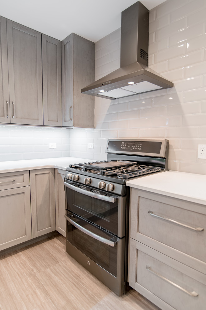 Inspiration for a mid-sized transitional u-shaped vinyl floor and gray floor enclosed kitchen remodel in Chicago with an undermount sink, recessed-panel cabinets, gray cabinets, quartzite countertops, gray backsplash, subway tile backsplash and stainless steel appliances