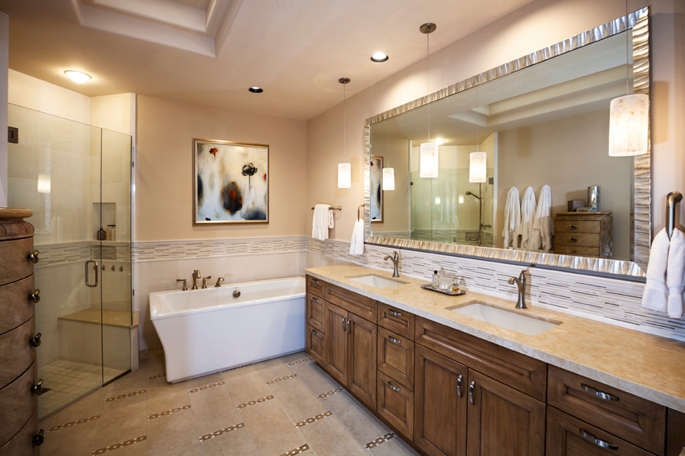 This is an example of a large transitional master bathroom in Phoenix with recessed-panel cabinets, medium wood cabinets, a freestanding tub, a curbless shower, beige tile, matchstick tile, beige walls, linoleum floors, an undermount sink, limestone benchtops, beige floor, a hinged shower door and a one-piece toilet.