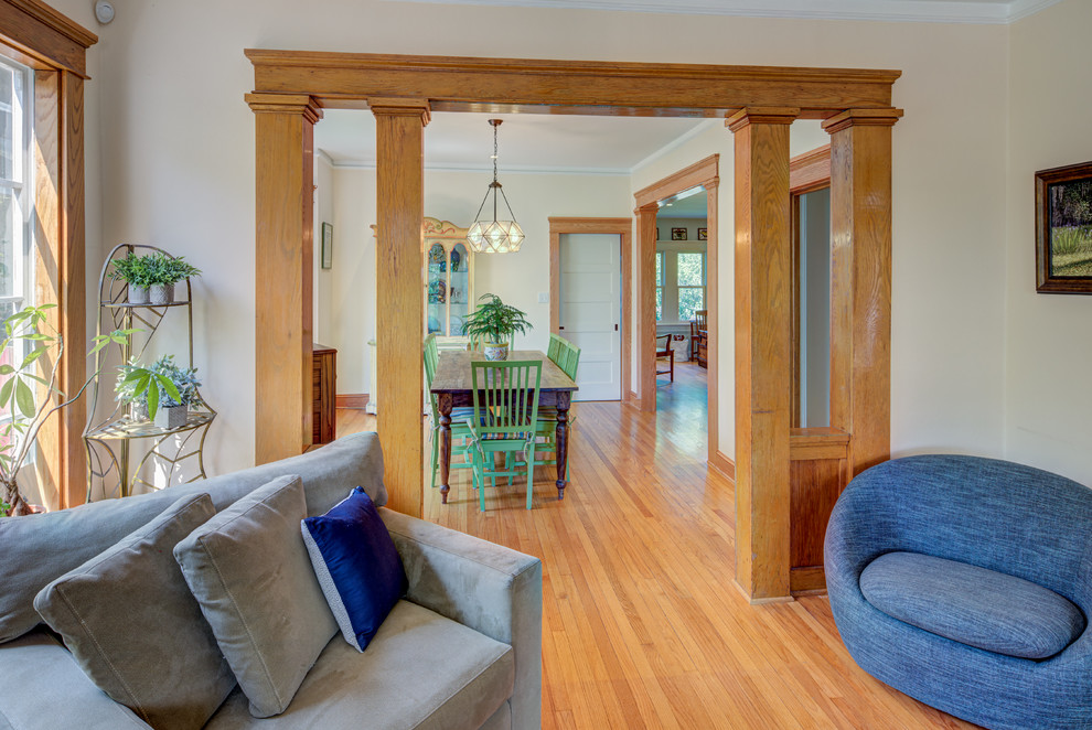 Mid-sized transitional enclosed living room in DC Metro with beige walls, light hardwood floors, a standard fireplace, a brick fireplace surround and yellow floor.