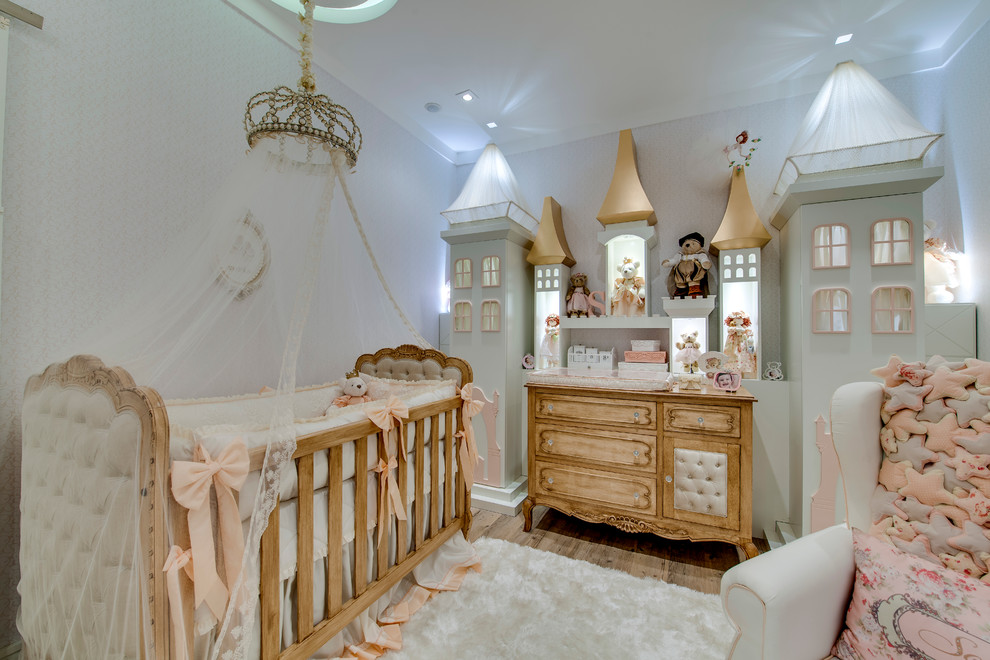 Mid-sized traditional nursery in Other with beige walls and medium hardwood floors for girls.