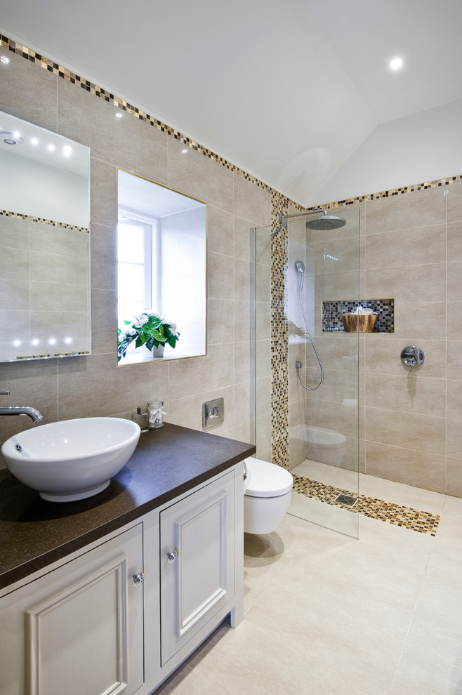 This is an example of a country bathroom in West Midlands with a vessel sink, recessed-panel cabinets, white cabinets, a corner shower, a wall-mount toilet, beige tile and beige walls.