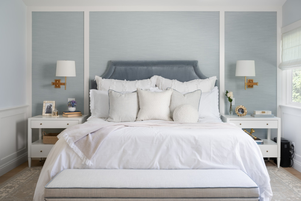 Großes Maritimes Hauptschlafzimmer mit blauer Wandfarbe, hellem Holzboden, gewölbter Decke und vertäfelten Wänden in Orange County