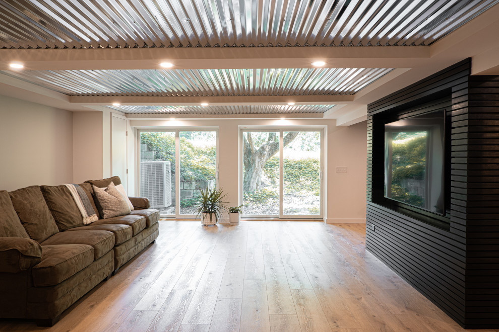 Example of a large 1960s walk-out light wood floor, brown floor, coffered ceiling and wood wall basement design in Baltimore with a bar and gray walls