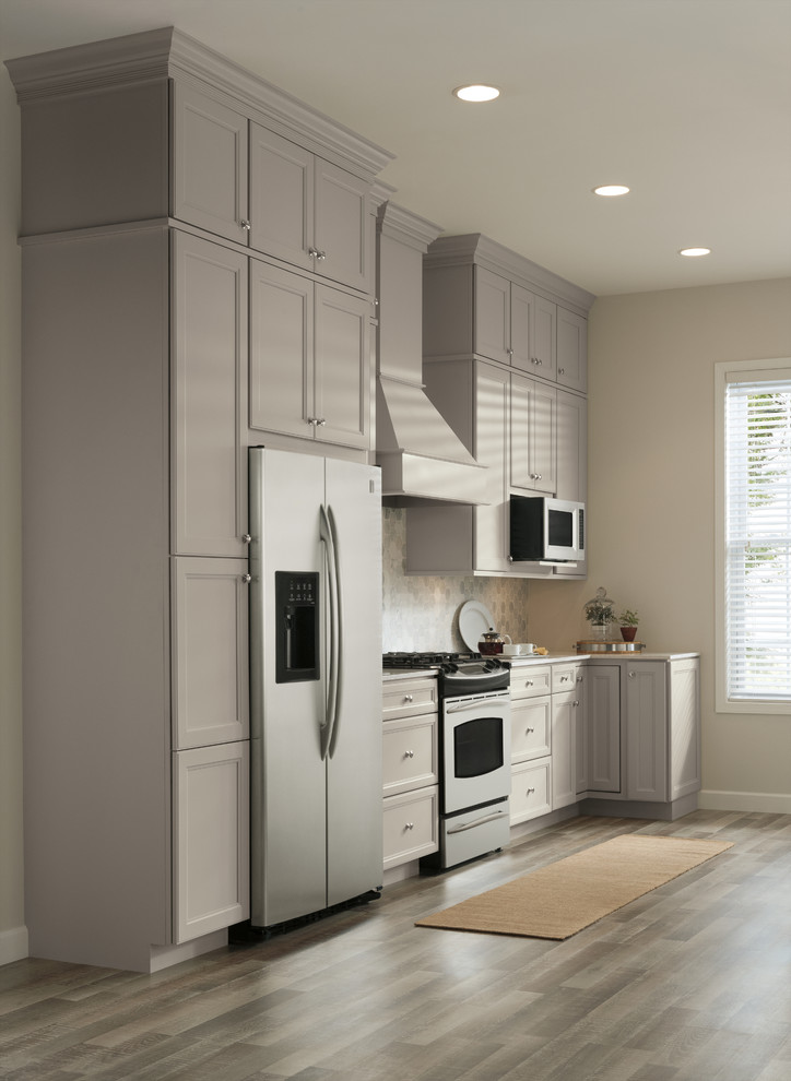 Eat-in kitchen - large transitional single-wall light wood floor eat-in kitchen idea with a farmhouse sink, shaker cabinets, gray cabinets, solid surface countertops, white backsplash, subway tile backsplash, stainless steel appliances and an island