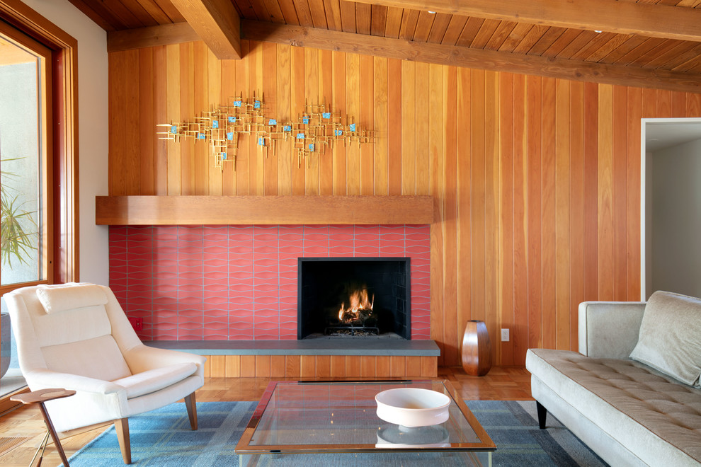 Design ideas for a mid-sized midcentury open concept living room in Los Angeles with multi-coloured walls, light hardwood floors, a standard fireplace, a tile fireplace surround and no tv.