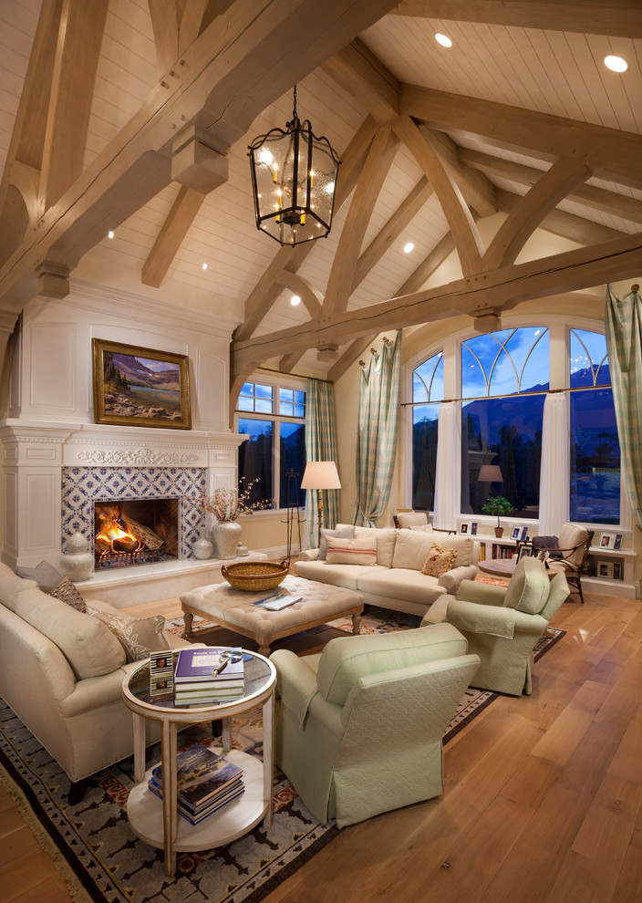 This is an example of a large traditional formal living room in Salt Lake City with a standard fireplace, a tile fireplace surround, white walls, medium hardwood floors, no tv and brown floor.