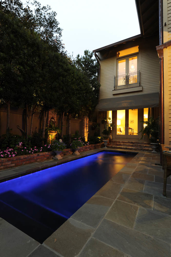 Mid-sized traditional backyard rectangular lap pool in New Orleans with natural stone pavers.