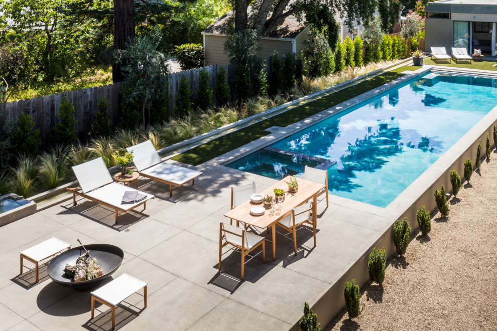 На фото: наземный бассейн среднего размера на заднем дворе в стиле модернизм с фонтаном с