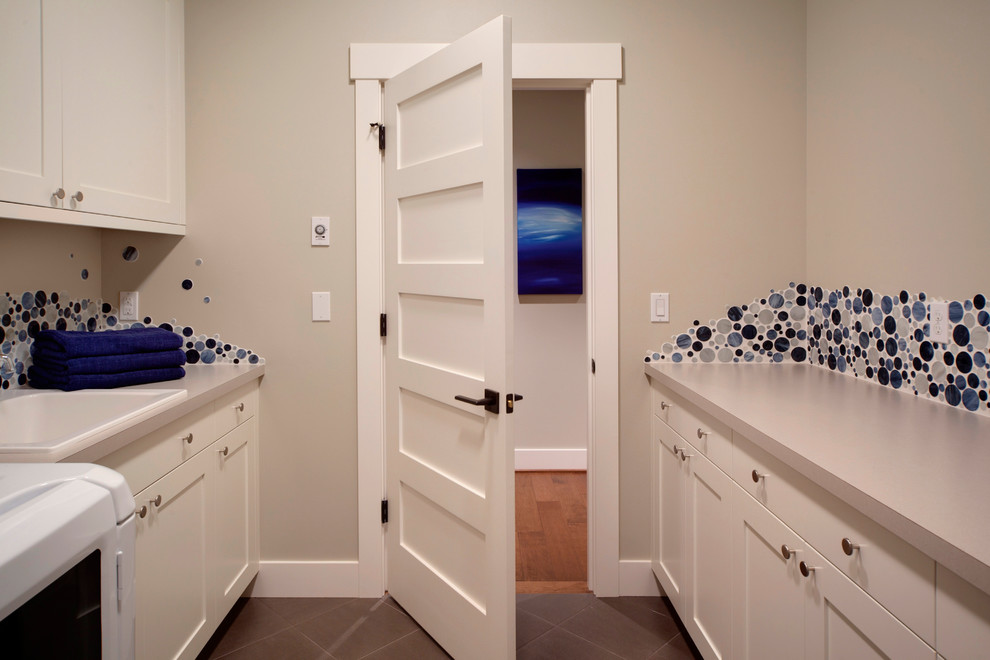 Inspiration for a mid-sized contemporary galley laundry room in Seattle with a drop-in sink, shaker cabinets, white cabinets, laminate benchtops, beige walls, ceramic floors and a side-by-side washer and dryer.
