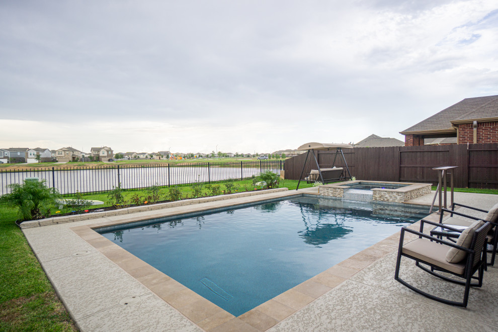 Aménagement d'une piscine arrière classique de taille moyenne et rectangle avec une terrasse en bois.