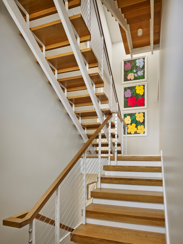 This is an example of a mid-sized contemporary wood u-shaped staircase in Philadelphia with open risers and metal railing.