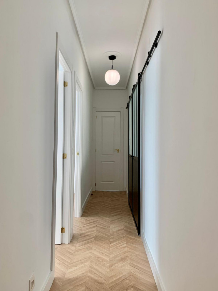 Идея дизайна: коридор в современном стиле с белыми стенами, полом из ламината и коричневым полом