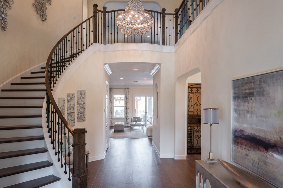 This is an example of an expansive transitional wood curved staircase in Jacksonville with painted wood risers.